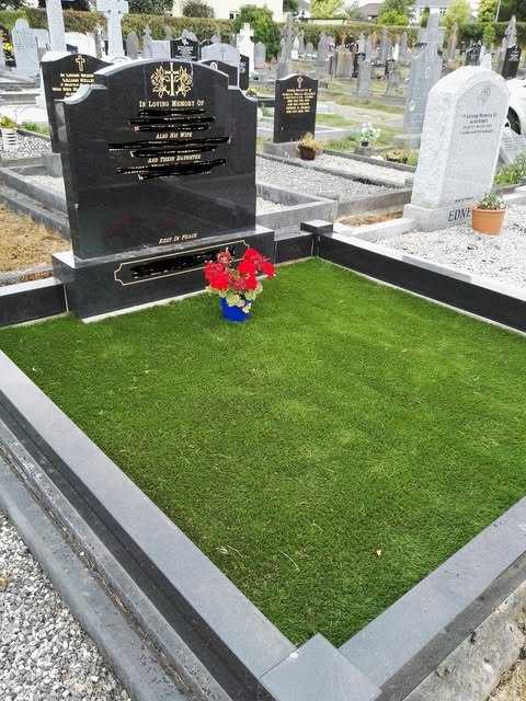 Black headstone with a grave plot fully covered in artificial grass