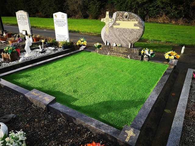 Grave with a timber-effect surround and green artificial grass infill