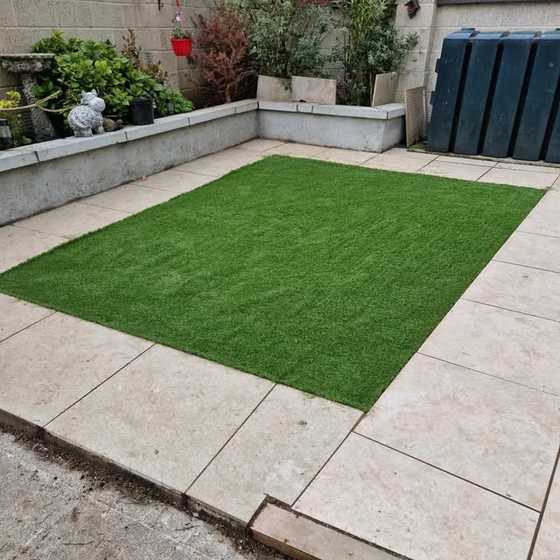 Finished artificial lawn surrounded by a cream paved patio